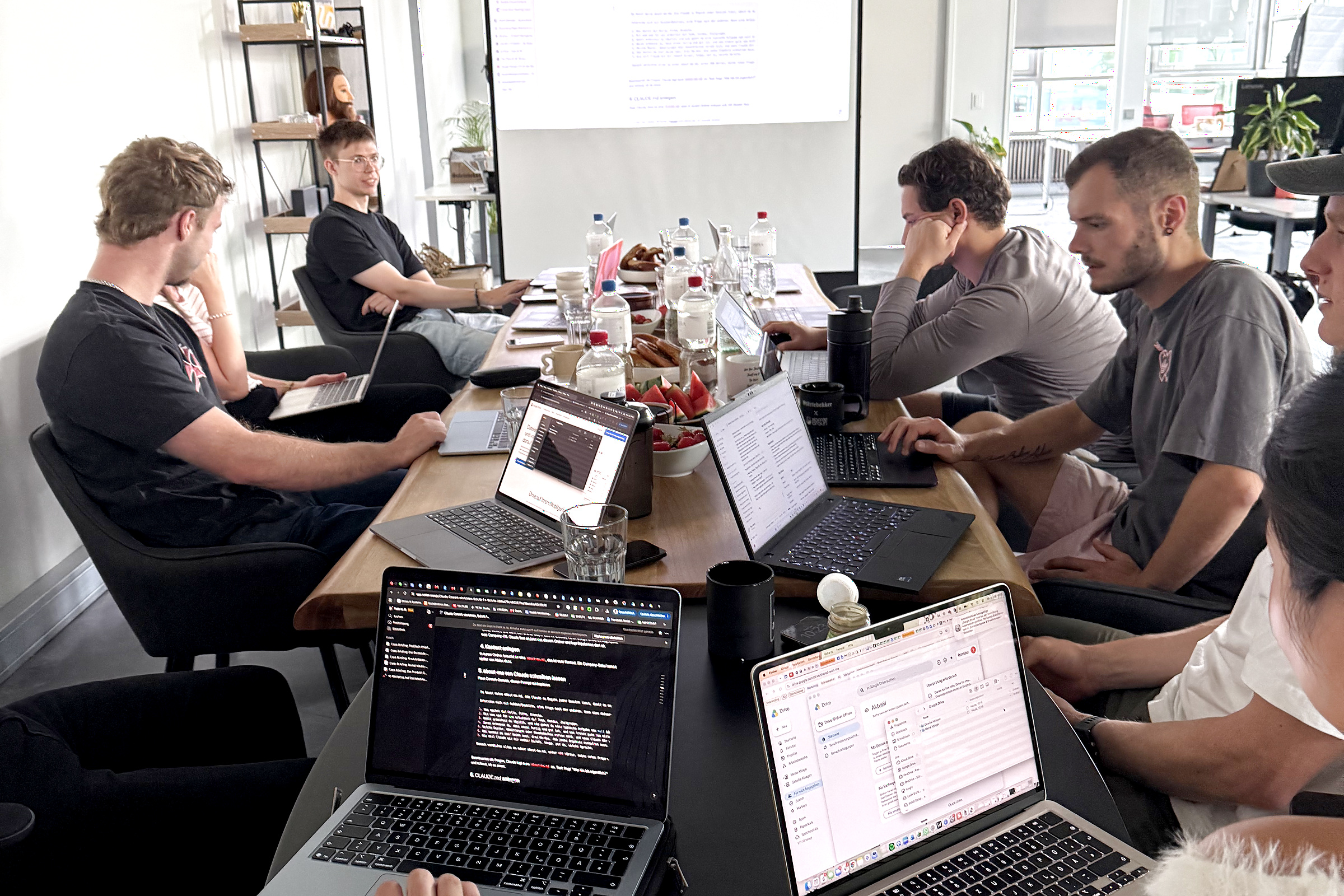 Das Team von Störtebekker arbeitet gemeinsam an einem langen Tisch mit mehreren Laptops.